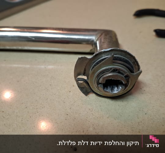 ידית דלת מתכת עם מנגנון נעילה שבור